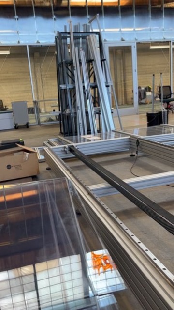 An assembled frame on a workbench with a sheet of clear acrylic panelling