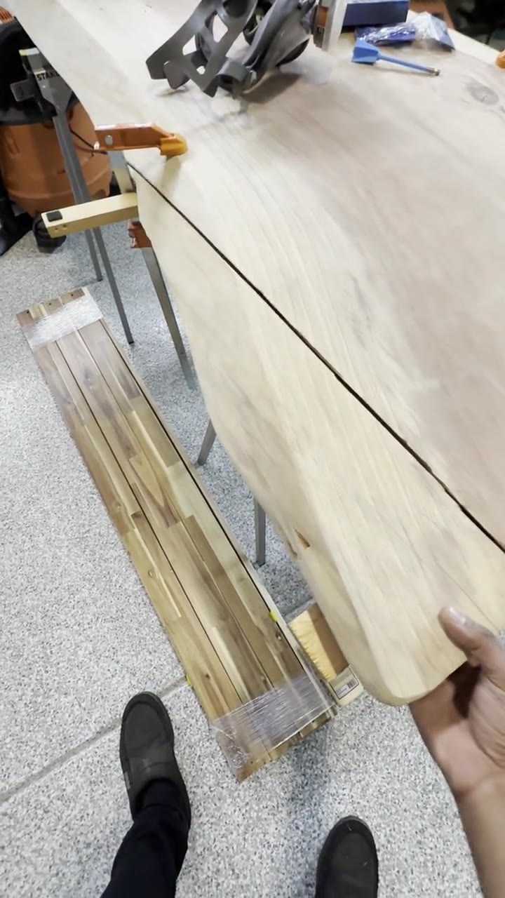 Holding the broken-off piece of live edge next to the slab