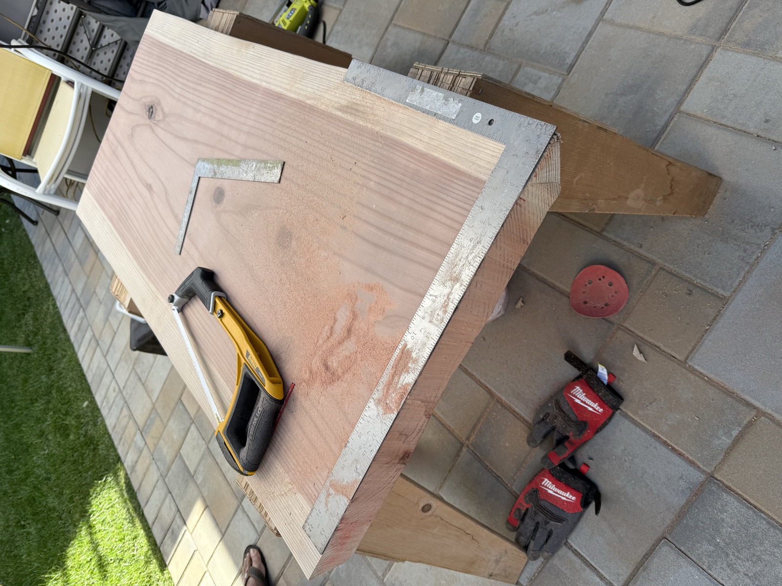 The slab on sawhorses with a framing square, hacksaw, and sawdust from a cut