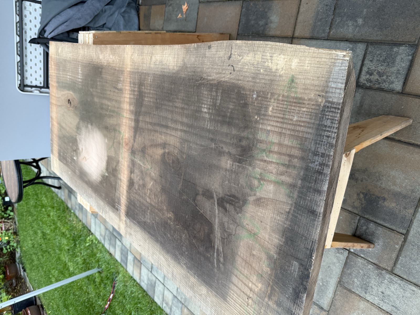 The raw slab on sawhorses, still showing saw marks and a dark weathered surface