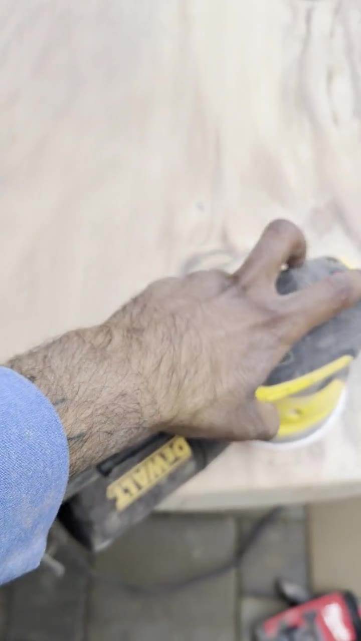 Sanding the cured epoxy flush with a DeWalt random orbital sander