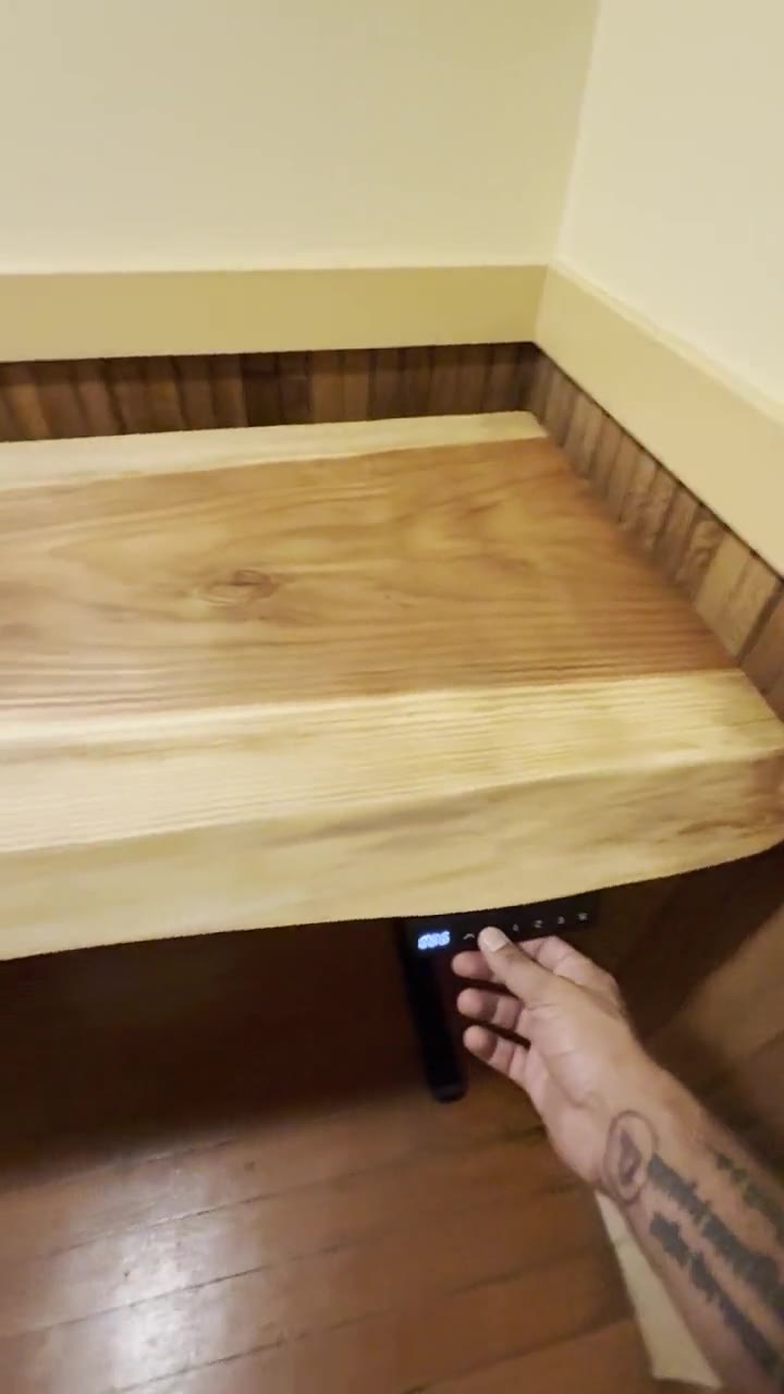 Pressing the height control under the finished live-edge standing desk