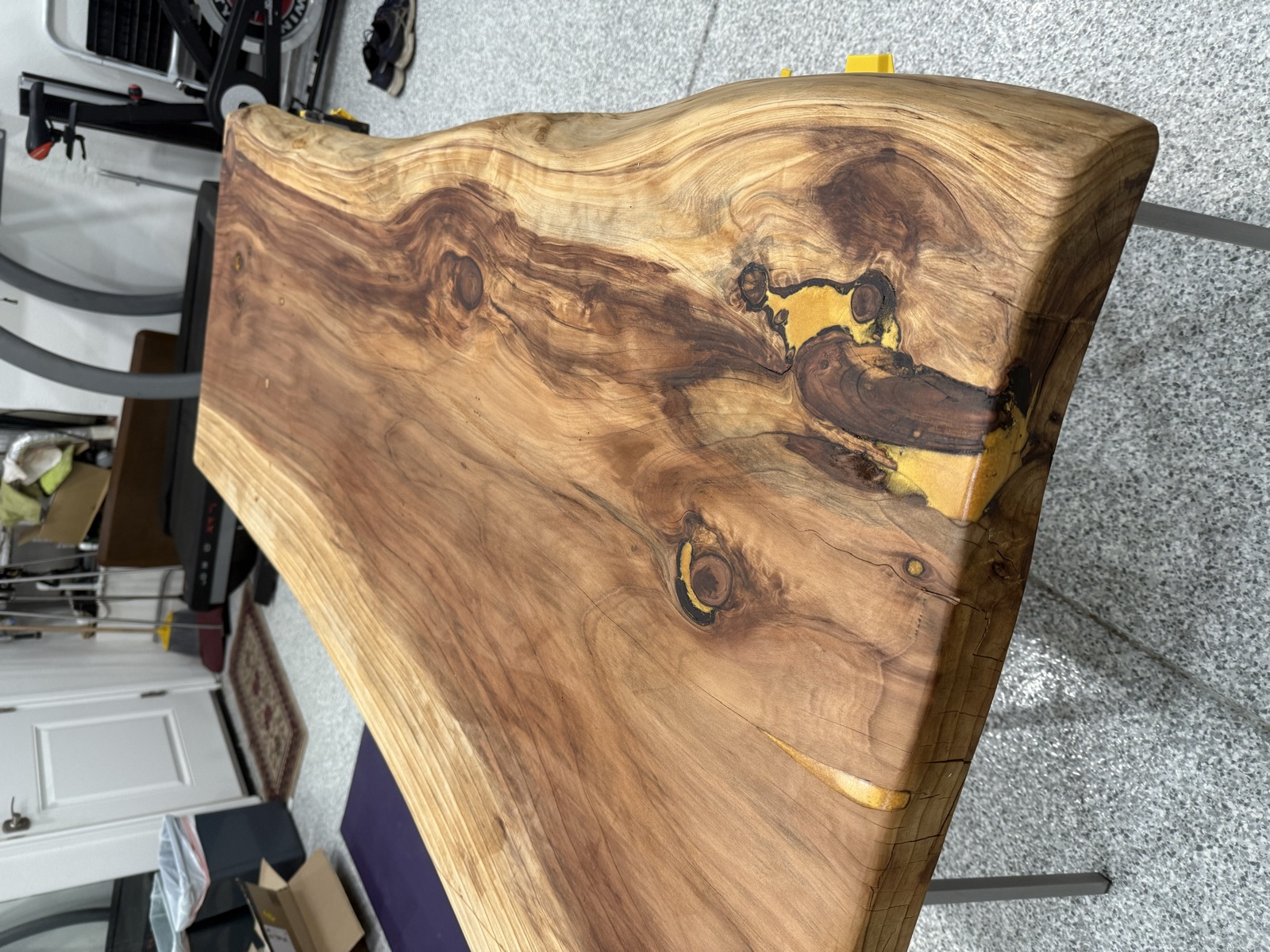 The finished second table on steel legs in the garage, gold epoxy filling a crack near the live edge