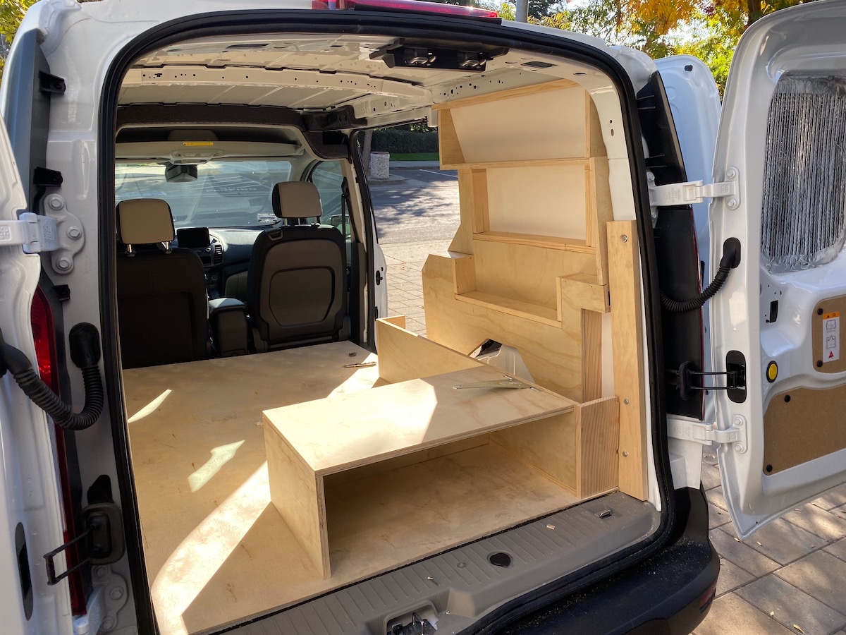 Plywood shelving and a stepped platform installed along one side of the cargo bay