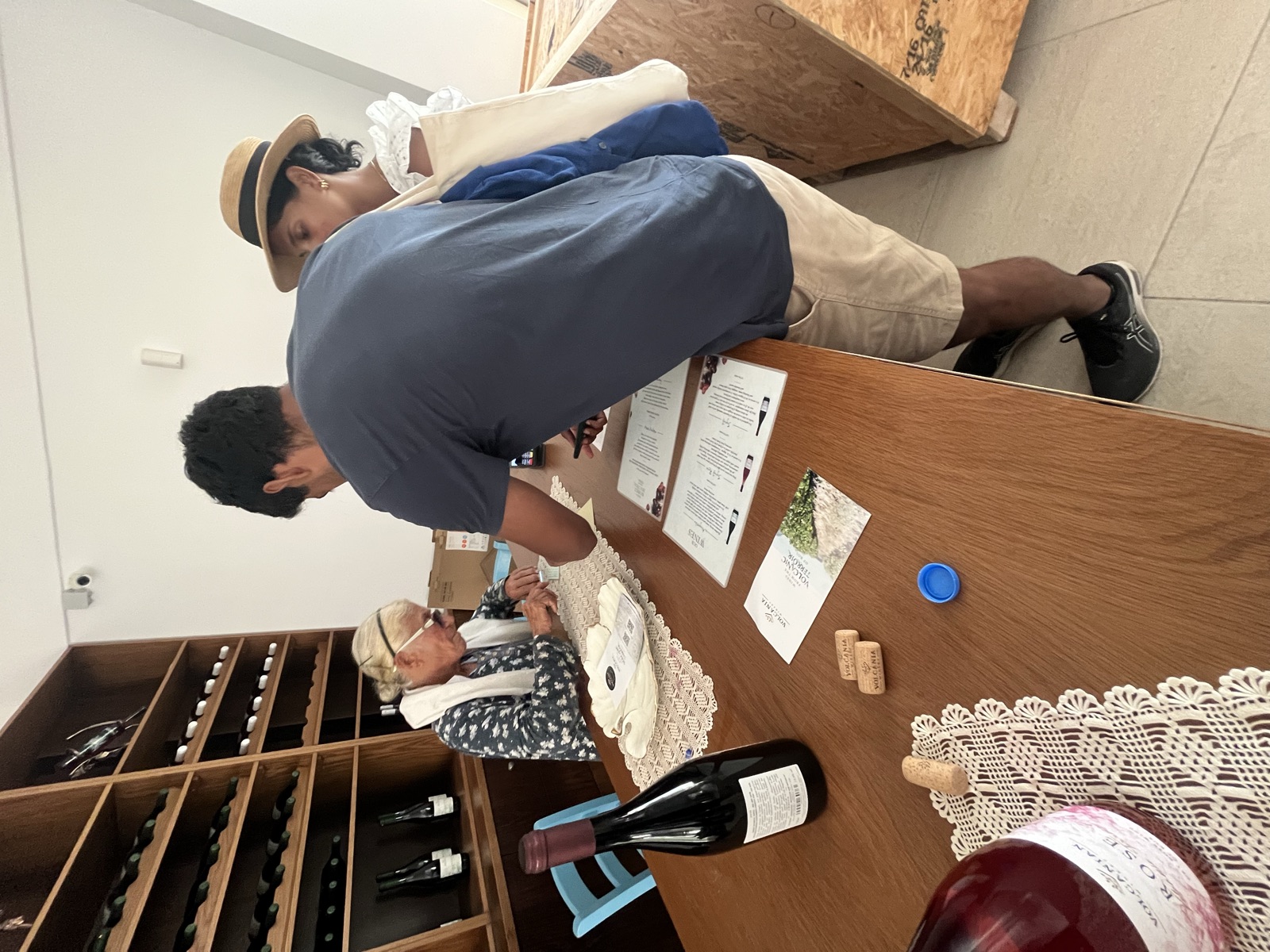 Buying wine at Volcania from a woman behind a wooden counter