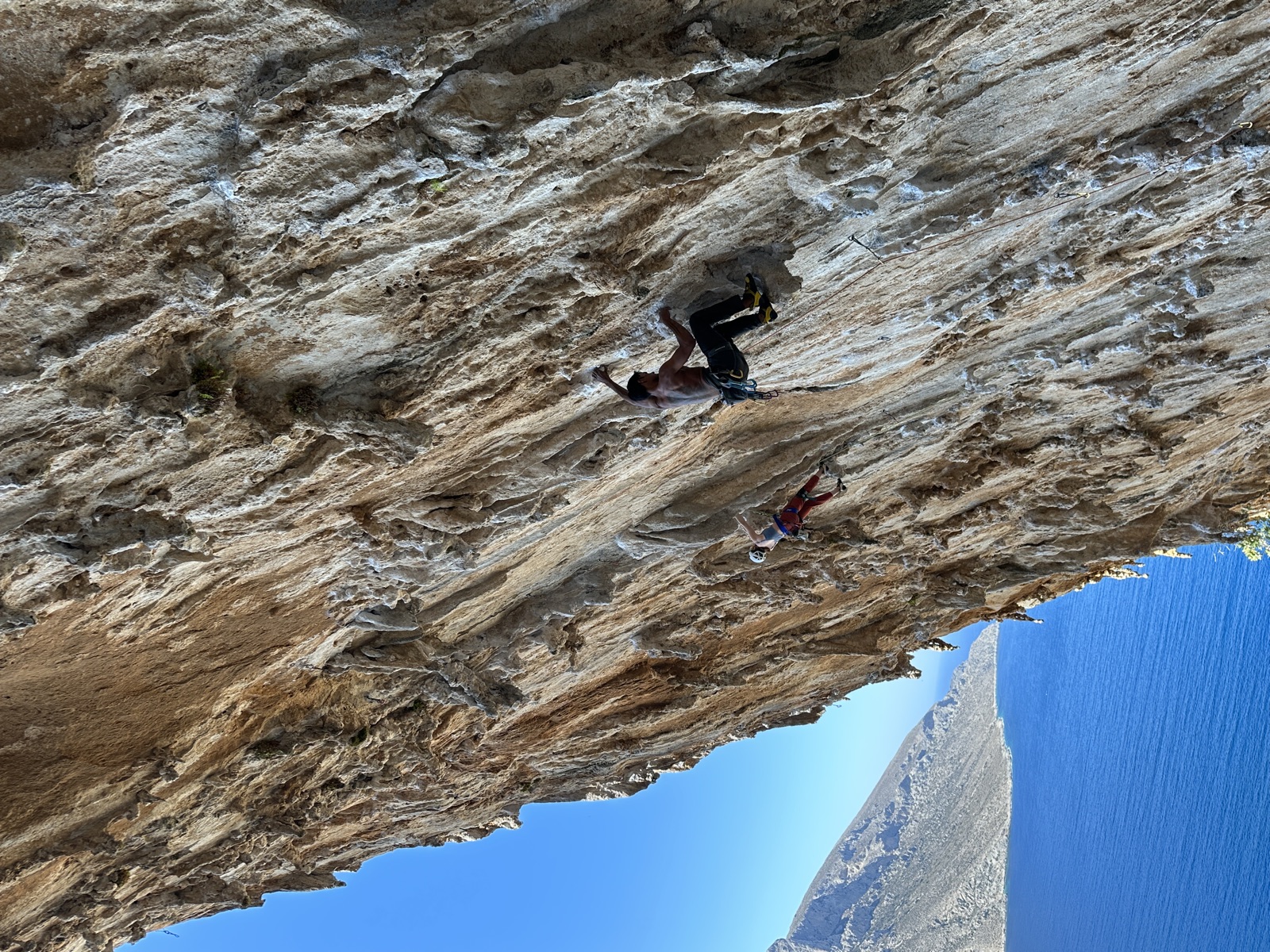 Higher on DNA with another climber on a line to the left and the sea below