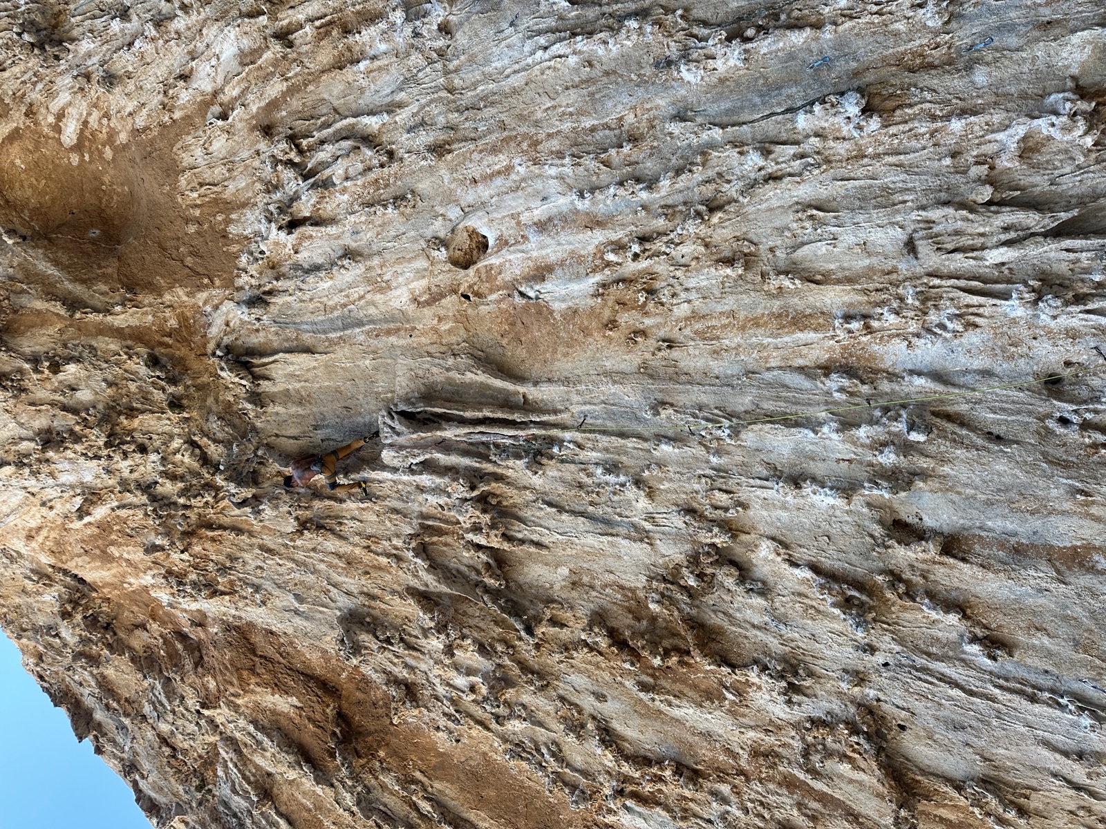 Standing on a tufa pillar around the sixth bolt, green rope hanging down the wall