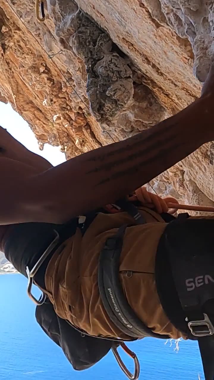 On Ivi, looking down past the harness and knee pad to the sea
