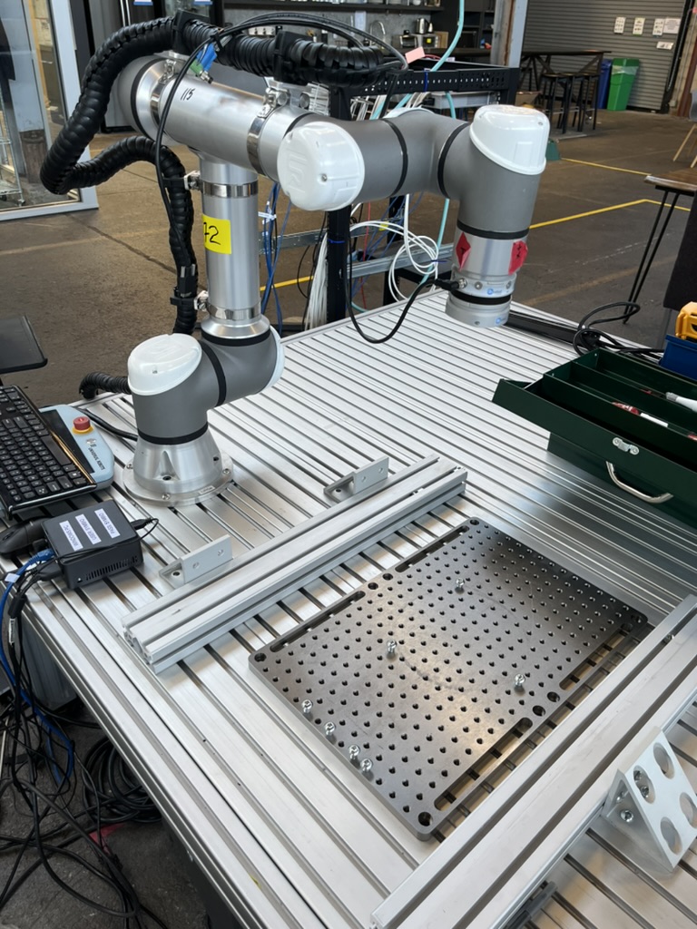 Two collaborative robot arms mounted on an aluminum extrusion workbench