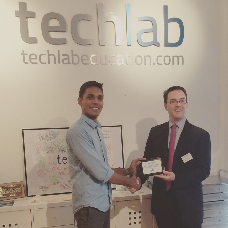 Receiving a membership plaque in front of the TechLab sign